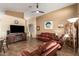 Living room featuring a fireplace, leather furniture, and large TV at 18258 W Spencer Dr, Surprise, AZ 85374