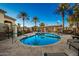 Community pool with lounge chairs and palm trees at 18258 W Spencer Dr, Surprise, AZ 85374