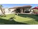 Landscaped backyard featuring a putting green and covered patio at 1893 E San Carlos Pl, Chandler, AZ 85249