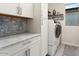 Bright laundry room with modern washer, dryer, and cabinets at 19027 N 269Th Dr, Buckeye, AZ 85396