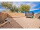 Large backyard with gravel, block wall, a trampoline, and a storage shed at 222 S 223Rd Dr, Buckeye, AZ 85326