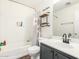 Cozy bathroom with dark wood vinyl floors, a shower-tub, and shelving with a modern mirror at 222 S 223Rd Dr, Buckeye, AZ 85326