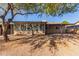 Home's backyard with covered patio, mature trees, and gravel landscaping at 2407 W Laurel Ln, Phoenix, AZ 85029