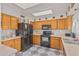 Kitchen with wood cabinets, black appliances, and tile floor at 2817 W Marshall Ave, Phoenix, AZ 85017