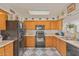 Galley kitchen with wood cabinets and black appliances at 2817 W Marshall Ave, Phoenix, AZ 85017