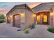 View of the home's entryway, showcasing a three-car garage and a charming front door at 28370 N 113Th Way, Scottsdale, AZ 85262