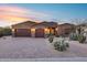 Desert landscape surrounds this single-story home with a three-car garage and an inviting entry at 28370 N 113Th Way, Scottsdale, AZ 85262