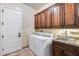 Laundry room with washer, dryer, sink, and plenty of cabinets at 28370 N 113Th Way, Scottsdale, AZ 85262