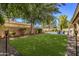 Spacious backyard with artificial turf, mature trees, and a pool at 302 S Laguna Dr, Gilbert, AZ 85233