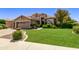 Two-story house with tan exterior, landscaping, and a large green lawn at 302 S Laguna Dr, Gilbert, AZ 85233