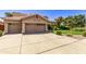 Two-story house with tan exterior, attached garage, and well-manicured lawn at 302 S Laguna Dr, Gilbert, AZ 85233