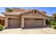 Two-story house with tan exterior, double garage doors, and nicely landscaped yard at 302 S Laguna Dr, Gilbert, AZ 85233