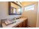 Clean bathroom with a single vanity, wood cabinets, and a window at 331 E Tuckey Ln, Phoenix, AZ 85012