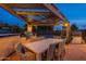 Outdoor dining area under a pergola, adjacent to a built-in grill and pool at 331 E Tuckey Ln, Phoenix, AZ 85012