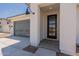 Modern front entrance with black door and gray garage door at 35775 N Zinc Dr, San Tan Valley, AZ 85144