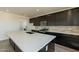 Modern kitchen with dark cabinetry, white quartz countertops, and stainless steel appliances at 35775 N Zinc Dr, San Tan Valley, AZ 85144