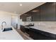 Modern kitchen with dark cabinetry, quartz countertops and stainless steel appliances at 35775 N Zinc Dr, San Tan Valley, AZ 85144