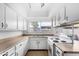 Bright eat-in kitchen with white cabinetry and an electric stove at 4303 W Solano N Dr, Glendale, AZ 85301