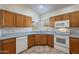 Kitchen area with oak cabinets, a double sink, and a corner window at 470 E Echo Ln, Florence, AZ 85132