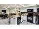 Open kitchen with breakfast bar, stainless steel sink, and white cabinetry at 4762 E Pawnee Cir, Phoenix, AZ 85044