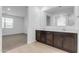 Double vanity bathroom with dark brown cabinets and a large mirror at 5030 W Hunter Trl, San Tan Valley, AZ 85144