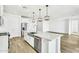 Modern kitchen featuring white cabinets, stainless steel appliances, and a large center island with a sink at 5030 W Hunter Trl, San Tan Valley, AZ 85144