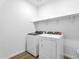 Bright laundry room featuring modern washer and dryer, complemented by stylish wooden floors and functional shelving at 5030 W Hunter Trl, San Tan Valley, AZ 85144