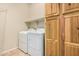 Laundry room with washer, dryer, and wood cabinets at 5219 W Buckskin Dr, Eloy, AZ 85131