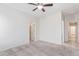 Bedroom with carpeted floor, ceiling fan and access to hallway at 5590 W Victory Way, Florence, AZ 85132