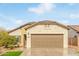 Tan house with a brown garage door and small front yard at 5590 W Victory Way, Florence, AZ 85132