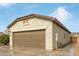 Side view of house showcasing a large two-car garage and stucco exterior at 5590 W Victory Way, Florence, AZ 85132