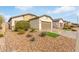 Light beige house with brown garage door, landscaping, and artificial turf at 5590 W Victory Way, Florence, AZ 85132