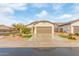 Single-story house with a two-car garage and desert landscaping at 5590 W Victory Way, Florence, AZ 85132