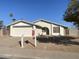 House exterior featuring a two-car garage and front yard at 702 W Grove Cir, Mesa, AZ 85210