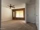 Bright living room with wood paneling and neutral carpet at 702 W Grove Cir, Mesa, AZ 85210