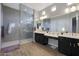 Elegant bathroom with double sinks, large shower, and dark wood cabinets at 9184 W Donald Dr, Peoria, AZ 85383