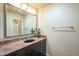 Bathroom featuring a dark vanity with granite counters, decorative mirror and modern lighting at 9288 E Camino Del Santo --, Scottsdale, AZ 85260