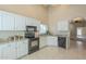 Spacious kitchen boasts white cabinets, stainless steel appliances, granite countertops, and tiled floors at 9288 E Camino Del Santo --, Scottsdale, AZ 85260