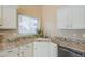 Close-up of a kitchen sink with granite countertops, white cabinets, and a window at 9288 E Camino Del Santo --, Scottsdale, AZ 85260