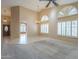 Spacious living room with neutral carpeting, plantation shutters, a ceiling fan, and access to other rooms at 9288 E Camino Del Santo --, Scottsdale, AZ 85260