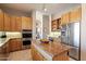 Spacious kitchen with island, stainless steel appliances, and wood cabinets at 10874 E Dale Ln, Scottsdale, AZ 85262