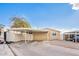 Tan single-wide mobile home with carport and landscaped yard at 10951 N 91St Ave # 56, Peoria, AZ 85345