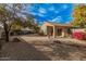 Spacious backyard with gravel landscaping and mature trees at 11921 W Port Royale Ln, El Mirage, AZ 85335