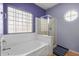 Bathroom with soaking tub, shower, and a block glass window at 13305 W Indianola Ave, Litchfield Park, AZ 85340