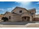 Two-story house with tan exterior, a three-car garage, and a landscaped front yard at 13305 W Indianola Ave, Litchfield Park, AZ 85340