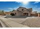 Two-story house with tan exterior, a three-car garage, and a landscaped front yard at 13305 W Indianola Ave, Litchfield Park, AZ 85340