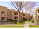 Tan apartment building with mature trees, green grass, and walkways in a well-maintained community at 145 N 74Th St # 207, Mesa, AZ 85207