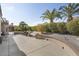 Spacious backyard patio with seating area, mature palm trees, and well-manicured landscaping at 16036 W Sandia Park Dr, Surprise, AZ 85374