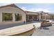 Rear view of house showing patio, large windows, and access to backyard at 16036 W Sandia Park Dr, Surprise, AZ 85374