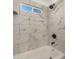 Clean bathroom with marble-look tile, a bathtub, and a shower at 1653 N 69Th Ave, Phoenix, AZ 85035